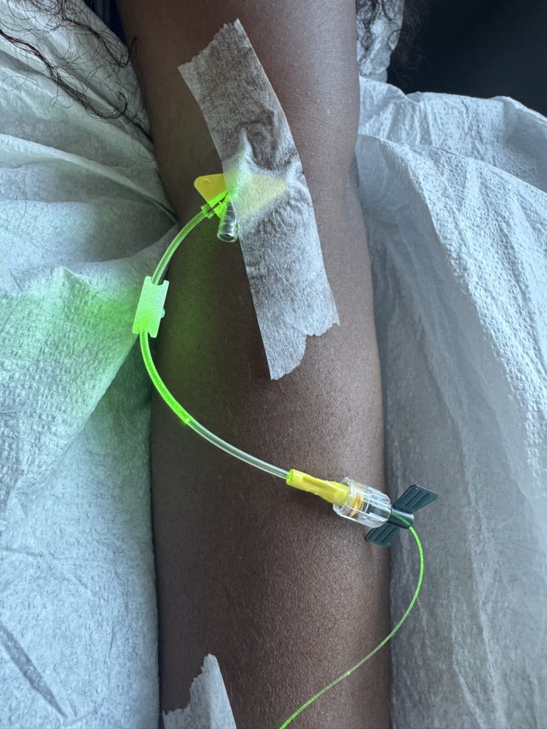 Green light visible along an intravenous line during a light-based treatment at LEMMO Cancer Care